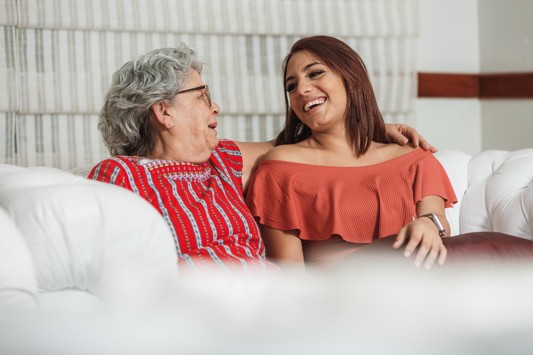An adult daughter sitting and talking with her mother at home